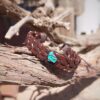 Leren armband met turquoise bedel op hout, boho stijl, handgemaakt, modieus accessoire.
