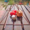 Kruiden en groenten in een metalen mand op houten tafel Verse tomaten, ui en knoflook op houten tafel in metalen mand.