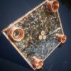Decoratief glazen dienblad met kristallen en koperen accessoires.